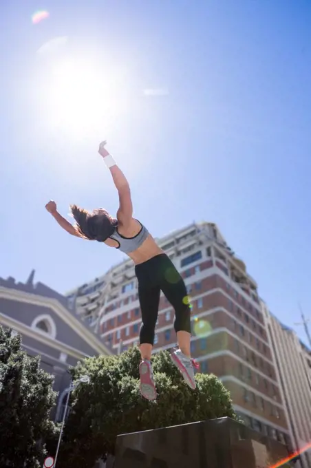 Woman doing parkour in the city on a sunny day