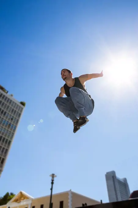 Man doing parkour in the city on a sunny day