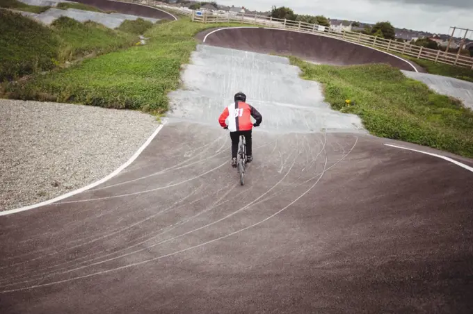 Rear view of cyclist riding BMX bike in skatepark