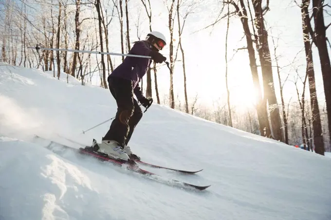 Skier skiing on the snow covered landscape in winter