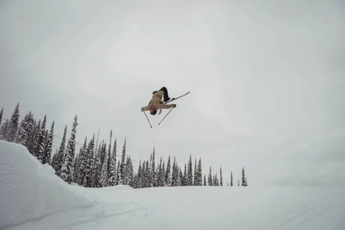 Man skiing on snowy alps in ski resort during winter