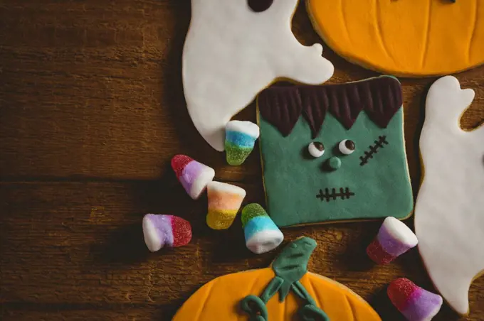 Overhead close up of cookies with candies on wooden table