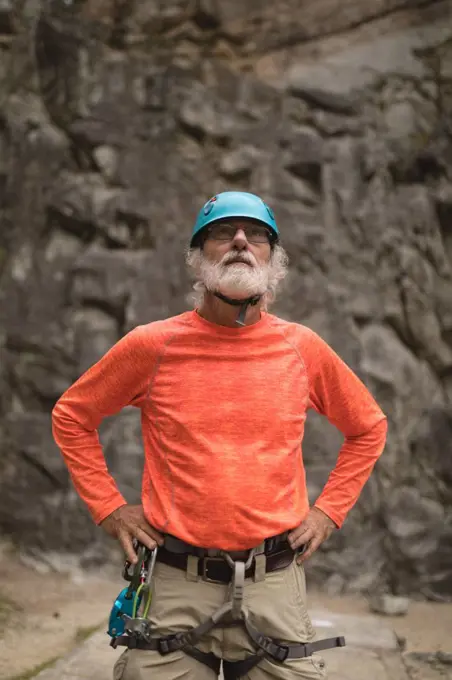 Thoughtful senior man wearing safety equipment during mountaineering