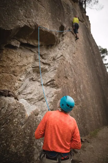 Rear view of man preparing for mountaineering