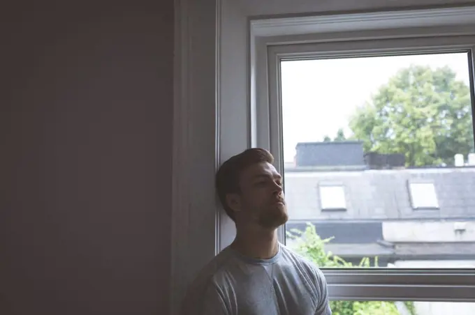 Worried man standing at home