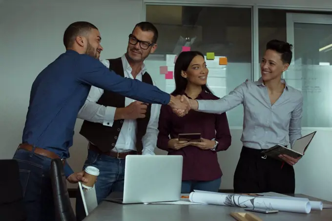 Smiling executives interacting with each other in office