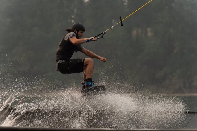 Young man wakeboarding in the river