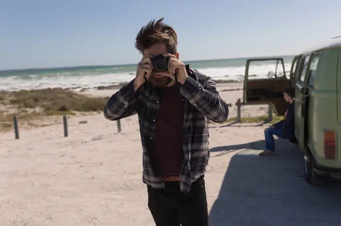 Man taking photo near beach on roadtrip