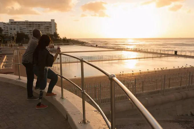 Couple having ice cream on promenade during sunset