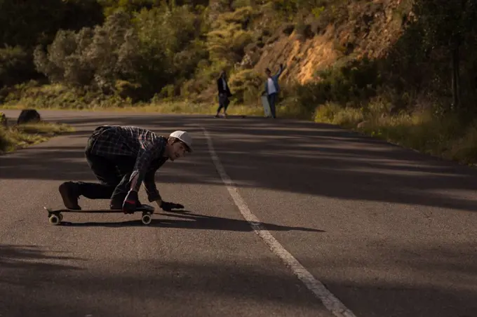 Young skateboarders skating on downhill at countryside