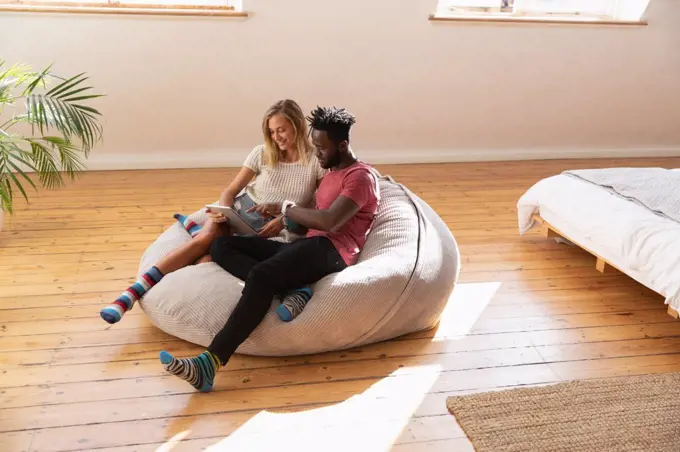 High angle view of multi ethnic couple using digital tablet in bedroom at home 