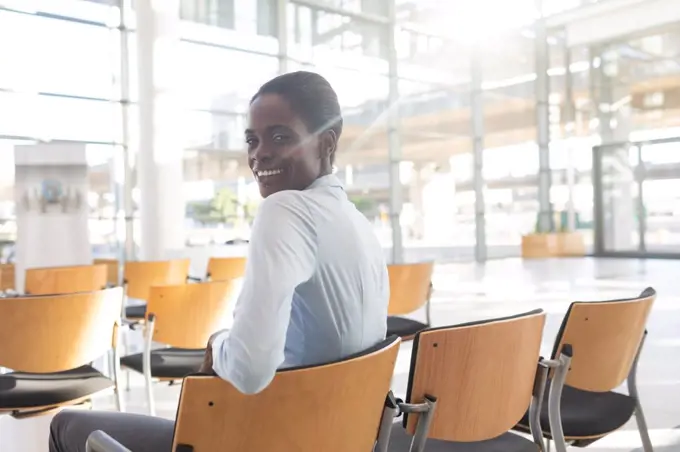 Side view of African-american woman sitting in conference room