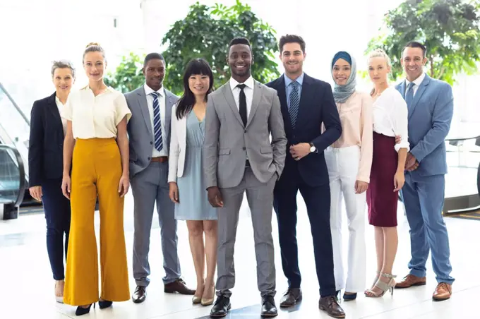 Front view of diverse executives all looking to camera in hall