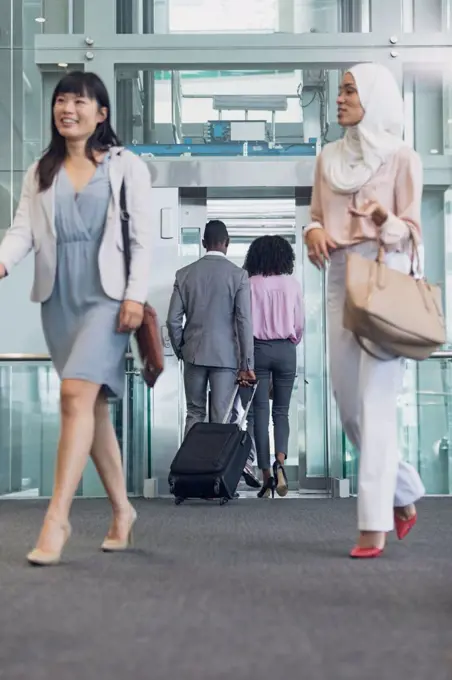 Front view of diverse female executives walking in corridor in modern office