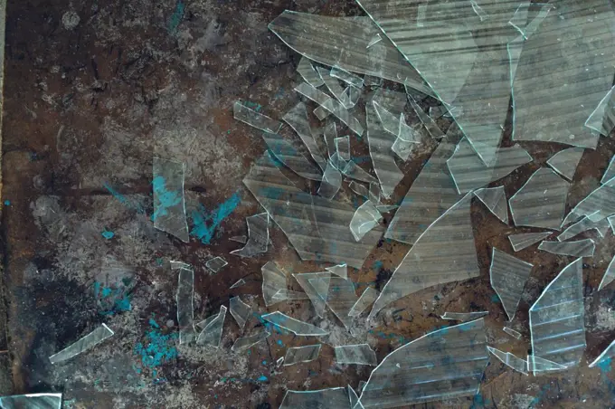 Close up detail of the interior of an abandoned warehouse space showing broken glass