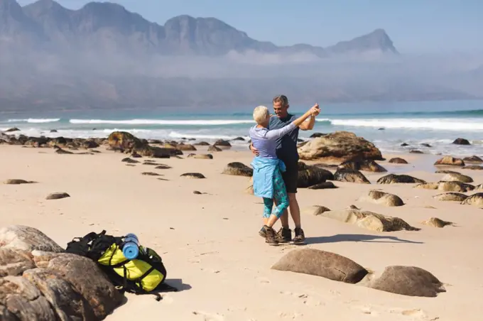 Senior couple spending time in nature together, walking on the beach, dancing. healthy lifestyle retirement activity.