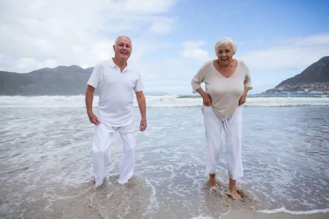 Happy senior couple having fun together at beach