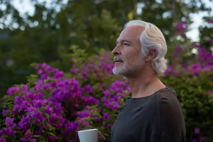 Thoughtful senior man having coffee in balcony