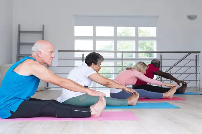 Diverse group of seniors taking part in fitness class at home. health fitness wellbeing at senior care home.