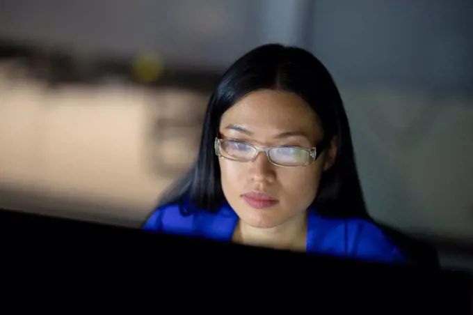 Asian businesswoman working at night using computer. working late in business at a modern office.