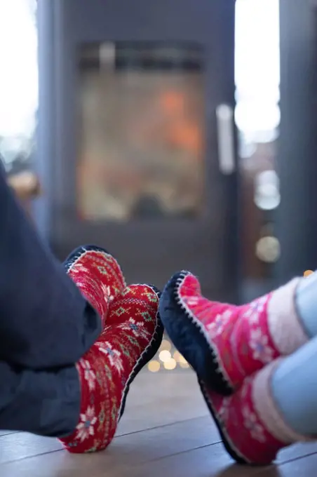 Close up of diverse couple in living room sitting by fireplace. spending time off at home.