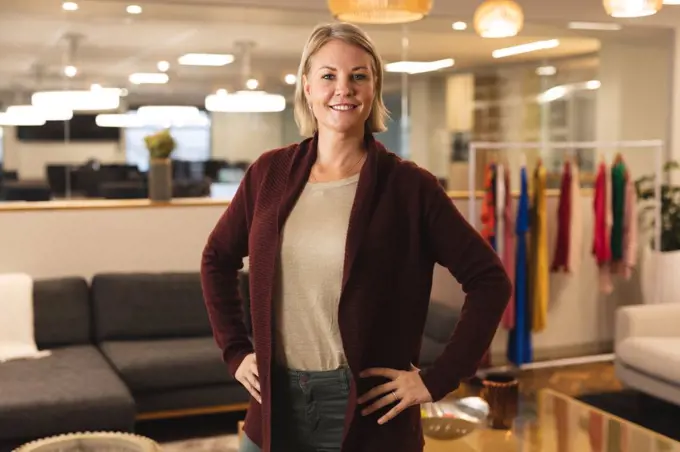 Portrait of smiling caucasian female creative looking to camera. working in creative business at a modern office.