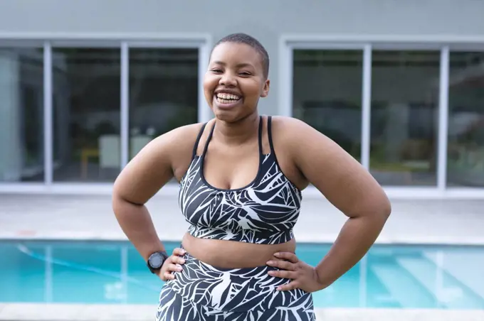 Happy african american plus size woman wearing sports clothes and looking at camera. fitness and healthy, active lifestyle.