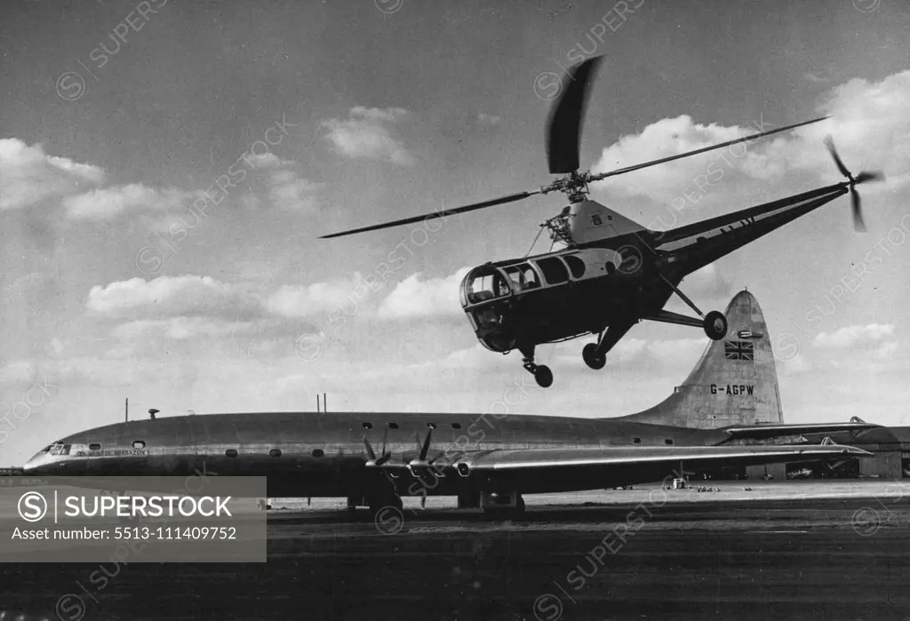 Helicopter Hovers Over Biggest Airliner -- Hovering around just like a bird a helicopter flies over the Bristol Brabazon, biggest air liner in the world, at Farnborough, Hampshire, England, where the Society of British Aircraft Constructors' display is being held. September 6, 1950.