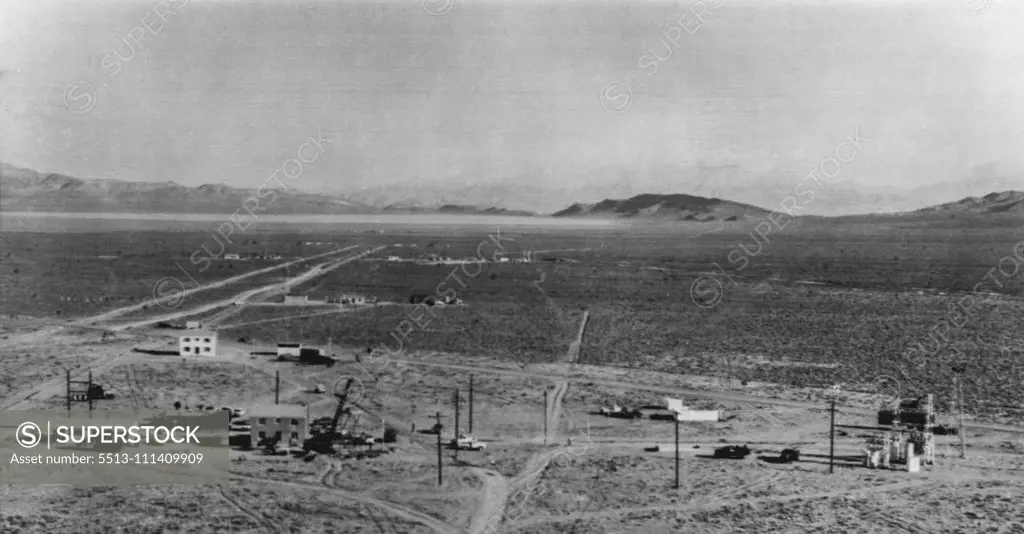 "Bomb's Eye" View Of Test Buildings -- This picture show's test structures spaced at different distances from a 500-foot tower in which a nuclear device will be set off Apr. 26th. First row including houses and a power plant (at right) is 4700 feet from the tower. Other buildings are at various distances with the big group in background at a 10,500 foot position. Pictures were taken with long focal length lenses. April 23, 1955. (Photo by AP Wirephoto).