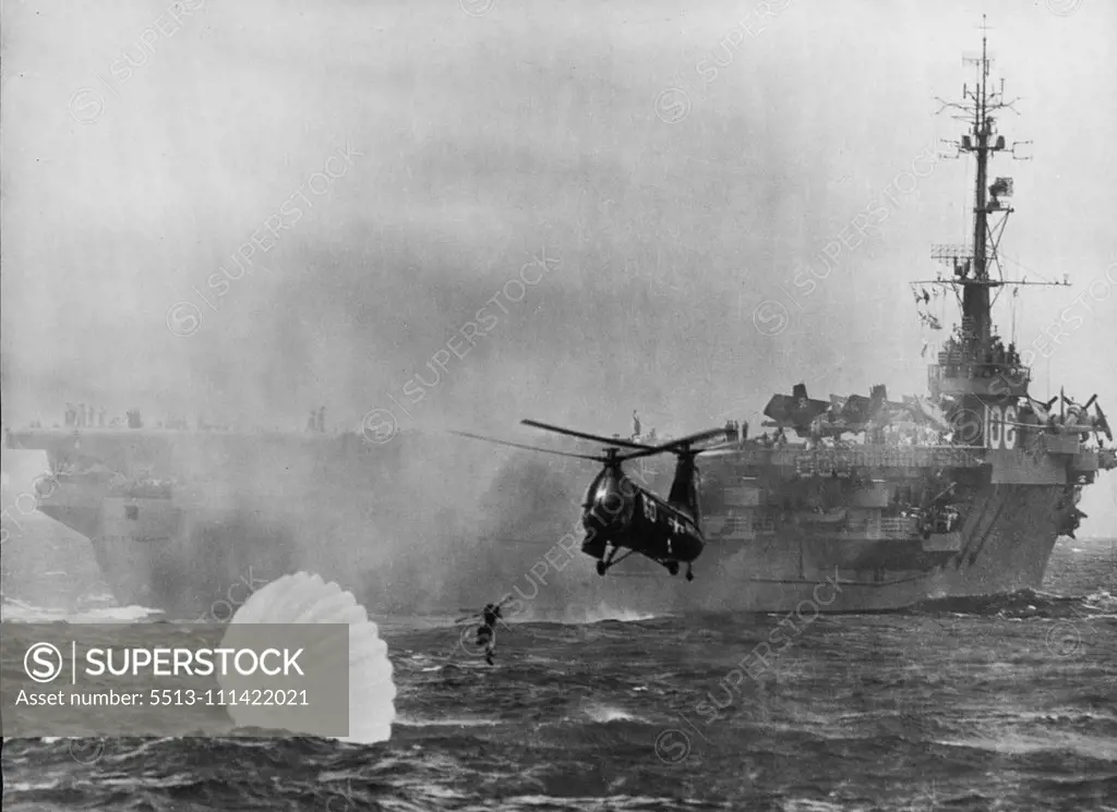 Helicopter Rescue On High Sea -- The use of helicopter is now standard equipment with the American Navy. Photograph shows a naval helicopter rescuing a parachutist from the sea. A line is released from the low-flying helicopter which enables the parachutist to be lifted on board. February 15, 1955. (Photo by Camera Press).