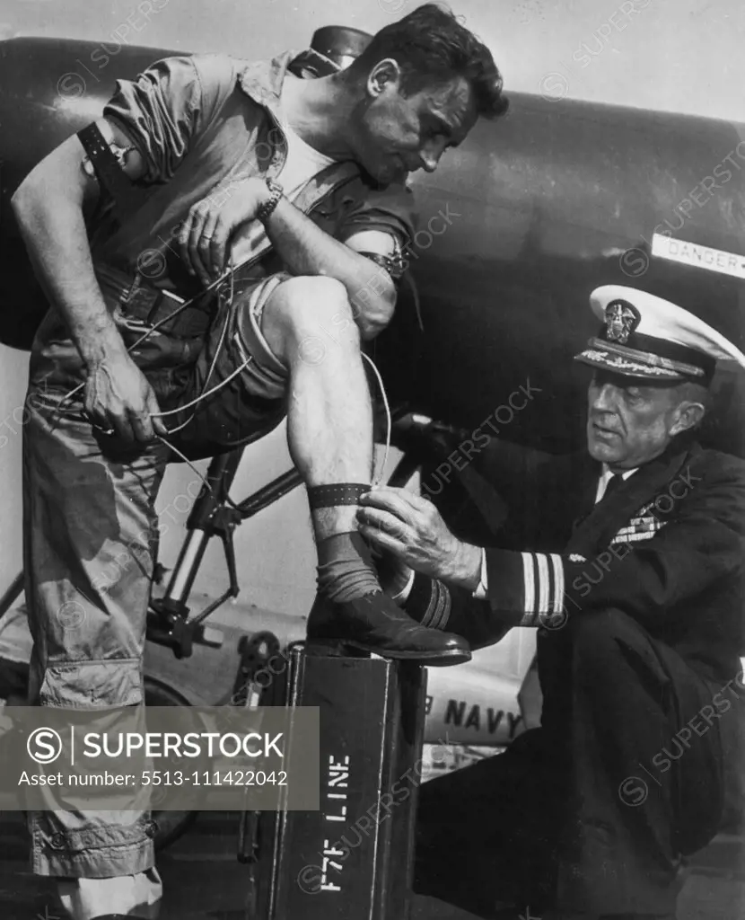 Wired For Sound Jet Flying -- Navy flight surgeon Comdr. Norman L. Barr attaches electodes to the body of pilot chief Joseph Kube during Navy's just completed series of successful tests and experiments for checking the minds and bodies of jet plane pilots while in flight. The electrodes register, through intricate radio devices, the heart and respiratory reactions during various stages of flight. The equipment was developed because of the number of air disasters caused by "pilot failure". Novemb