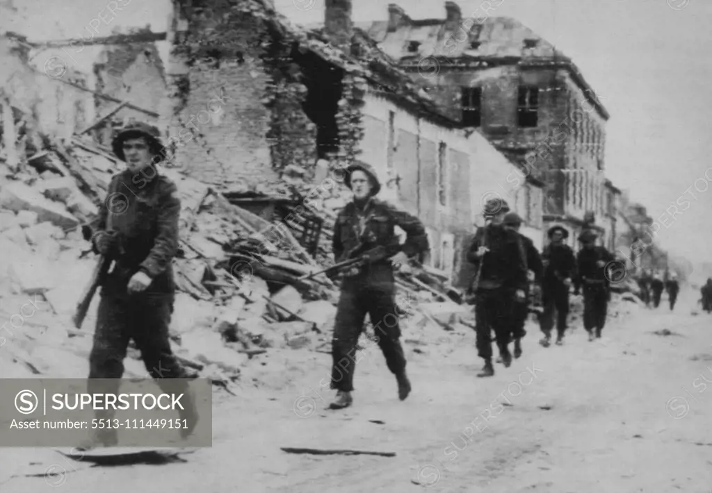 Allies Push Through Caen -- Continuing the drive which wrested the city of Caen from enemy hands, Allied troops pour through the Normandy coast community in pursuit of withdrawing German forces, giving them no opportunity to regroup. These troops are enroute to the front. This is a Canadian official photo. July 11, 1944. (Photo by Associated Press Radiophoto).