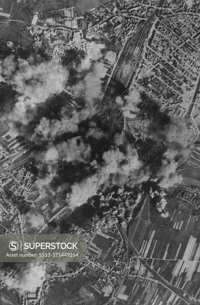 Lethal Bursts -- Heavy concentrations of bombs blossom on or near the marshalling yards at Belfort as American heavy bombers of the U.S. Eighth A.A.F. pressed home their attack on May 25th. Many hits were made on repair shops and fires started in rolling stock. May 31, 1944. (Photo by Fox Photos).