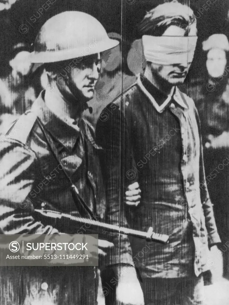 Commando Returns With Prisoner -- Back in Britain after the big Commando raid on Dieppe in German-occupied France, this stern Commando leads a blind-folded German prisoner. August 20, 1942 (Photo by AP Wirephoto).