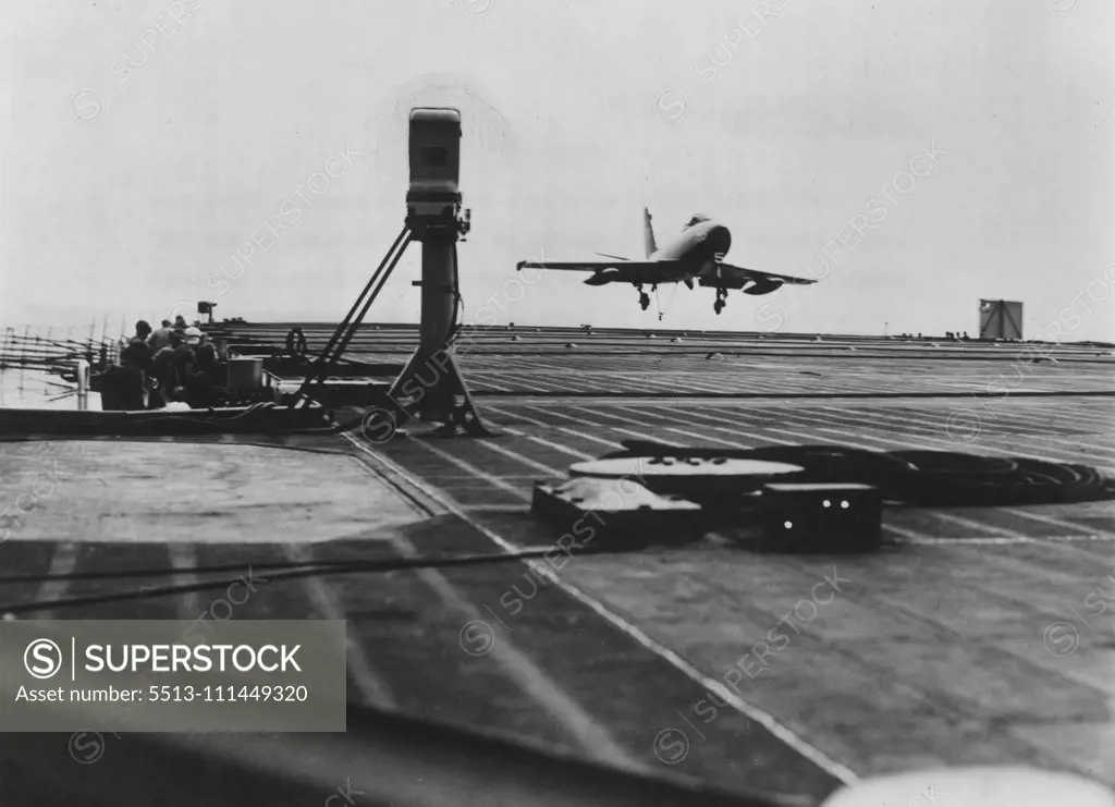 Trodi Checks Fury : Speed of a Navy North American XFJ-2 Fury Jet is checked by Trodi (padestal at left) as it lands on the USS Midway. The new instrument, a touchdown, rate of descent indicator, was developed and built by North American's Electro-Mechanical Department. It makes it possible to determine the proper rate of descent for carrier landing in a fraction of the time previously required. Trodi sends out two beams of light which the approaching plane intersects and the instrument then rec