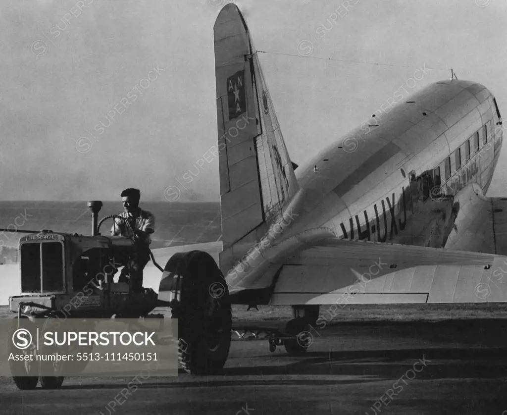 Fleet in the air but humbled on the ***** have to be towed by a tractor into the hangar. The Loonagana, of A.N.A., being put away ***** Airport, after flying the Melbourne run. December 12, 1938.