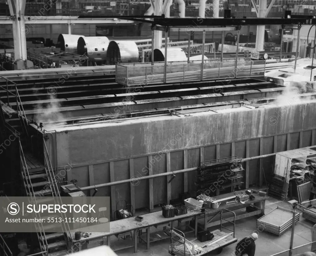 Airplanes En Masse -- Photo taken from overhead crane bay at Lockheed Aircraft Corporation's final assembly line in Burbank, Calif., shows big new transports and radar airplanes marching to completion in close ranks. Note comparative size of workman on floor below 50-foot horizontal stabilizer of the first transport and men on the tail of the second. Multimillion dollar array of airplanes above include big new Super-G transports for Eastern Air Lines and TWA (foreground) and early warning radar 