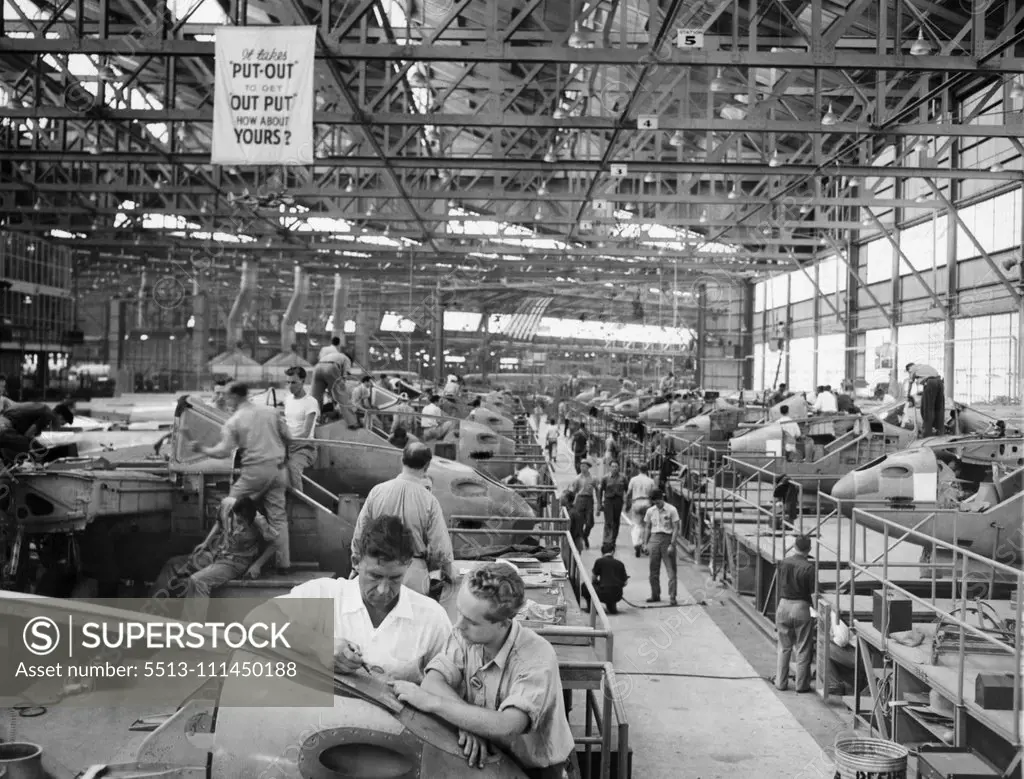 Wants To Advance -- Kenneth McMahon, (Right) talks over a detail of the manufacture of airlines at the Lockheed plant, Burbank, Cal., with Todd Oviatt, his superior. He hopes by successive "Upgradings" eventually to step into a supervisor's shoes. That's why he has been spending a couple of nights a week in study. Scene inside one of the great construction hangars of the Lockheed Aircraft Corporation at Burbank, California. July 20, 1941. (Photo by Associated Press Photo).