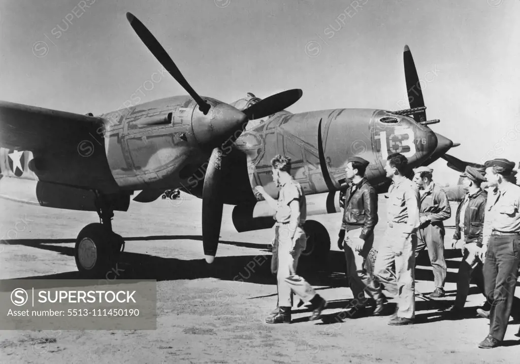 New U.S. Planes Arrive In Australia -- American fighter pilots inspect a newly arrived P-38 "Lightning", one of a large shipment of the U.S. fighter-interceptors which arrived recently in Australia. The P-38's, which had already seen service against the Axis in Europe and Africa, base their offensive strength on (1) high altitude performance, (2) speed in excess of 400 miles per hour and (3) strong firepower, including heavy machine guns and automatic cannon. February 22, 1943. (Photo by Interph