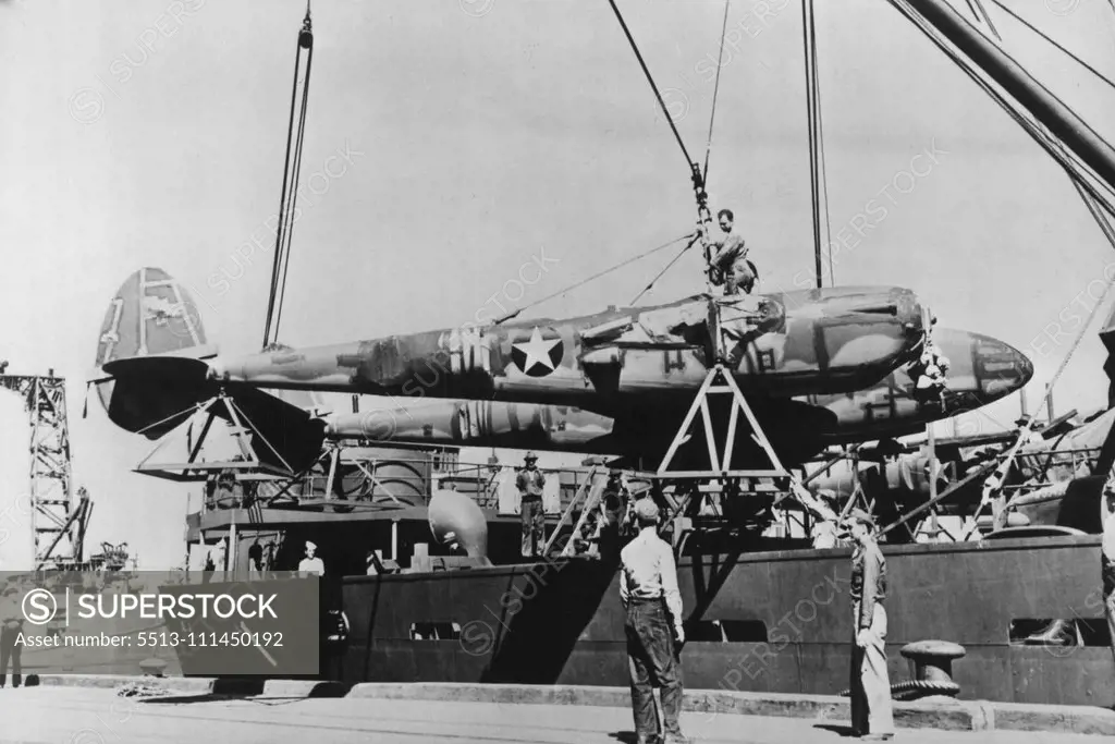 New U.S. Planes Arrive In Australia -- A P-38 "Lightning" is unloaded on a pier somewhere in Australia, one of a recent large shipment to arrive there from the U.S. The P-38's are rated with the best high altitude interceptor and fighter planes in the world, attaining a speed in excess of 400 miles per hour. It is a twin-motored plane with the main armament mounted in the center fuselage section. February 08, 1943. (Photo by Interphoto News Pictures, Inc.).