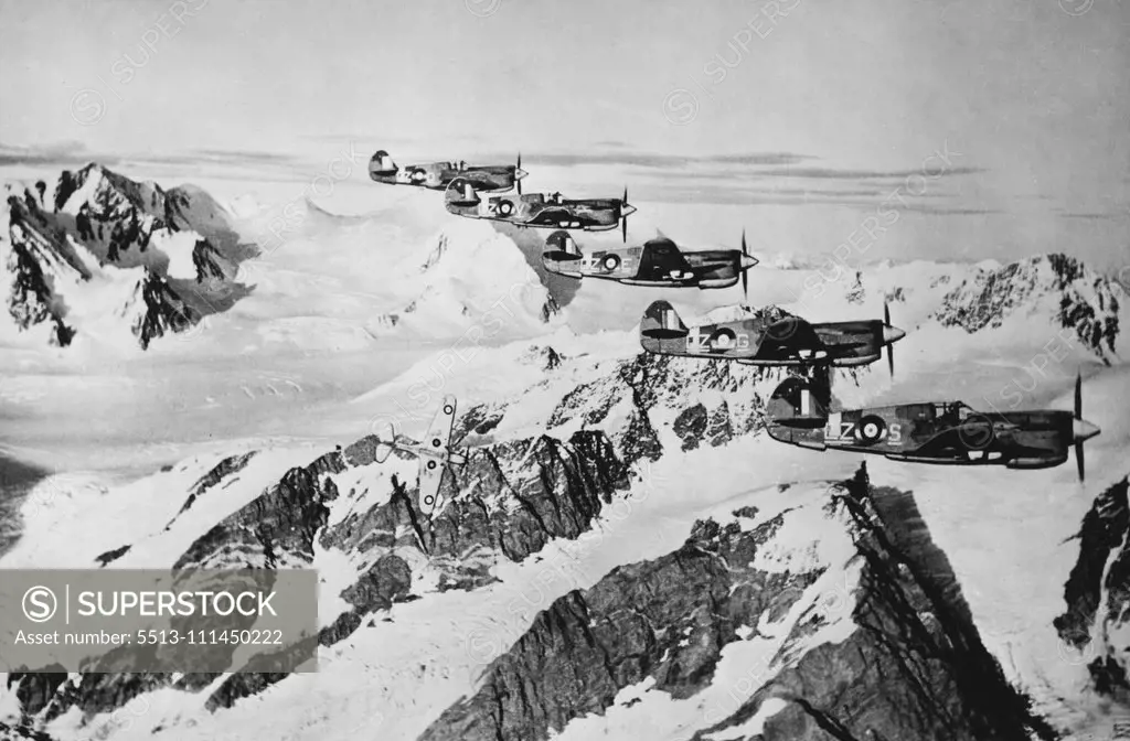 Canadian Airmen Cooperate with U.S. In Operations off American west Coast -- Kittyhawk fighter planes of the Royal Canadian Air Force wing in formation over an Alaskan mountain range in one of the patrol operations in which Canadian flyers are cooperating with United states airmen in operations in the North Pacific area. October 11, 1943.