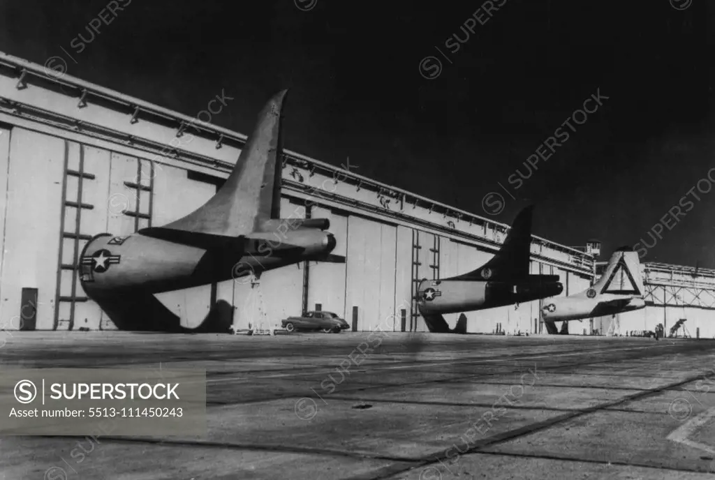 The Building's Big, But Not Big Enough - The tail structures of these early-modes B-36B air-planes are too big for the Consolidated Vultee aircraft plant here where they are being modernized into jet-augmented B-36D bombers. So the company cut circular holes in huge sliding doors for this porthole-like effect, while work proceeds on forward portions of the planes inside. October 13, 1950. (Photo by AP Wirephoto).