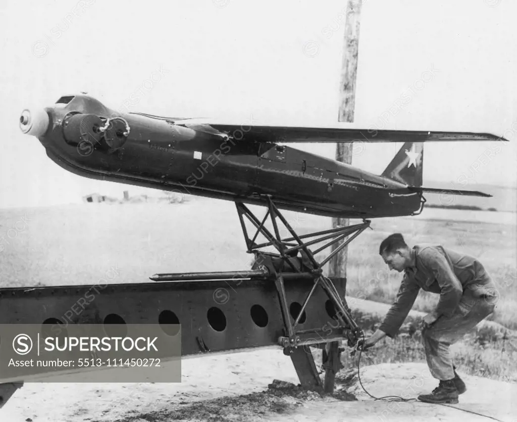 Target For Track-and-Destroy Anti-Aircraft Gun -- An "R-Cat" 300-mile-per-hour, radio-controlled target airplane is prepared for take-off at demonstration at Weybourne, England, during test of new U.S. 75mm skysweeper Anti-Aircraft gun. The new gun, demonstrated for senior British officers and reporters by the 32nd Anti-Aircraft Artillery Bridge, has built-in radar and an electronic brain that works cut speeds, heights and angles. It can fire 22 12-pounder shells in 30 seconds at aircraft flying