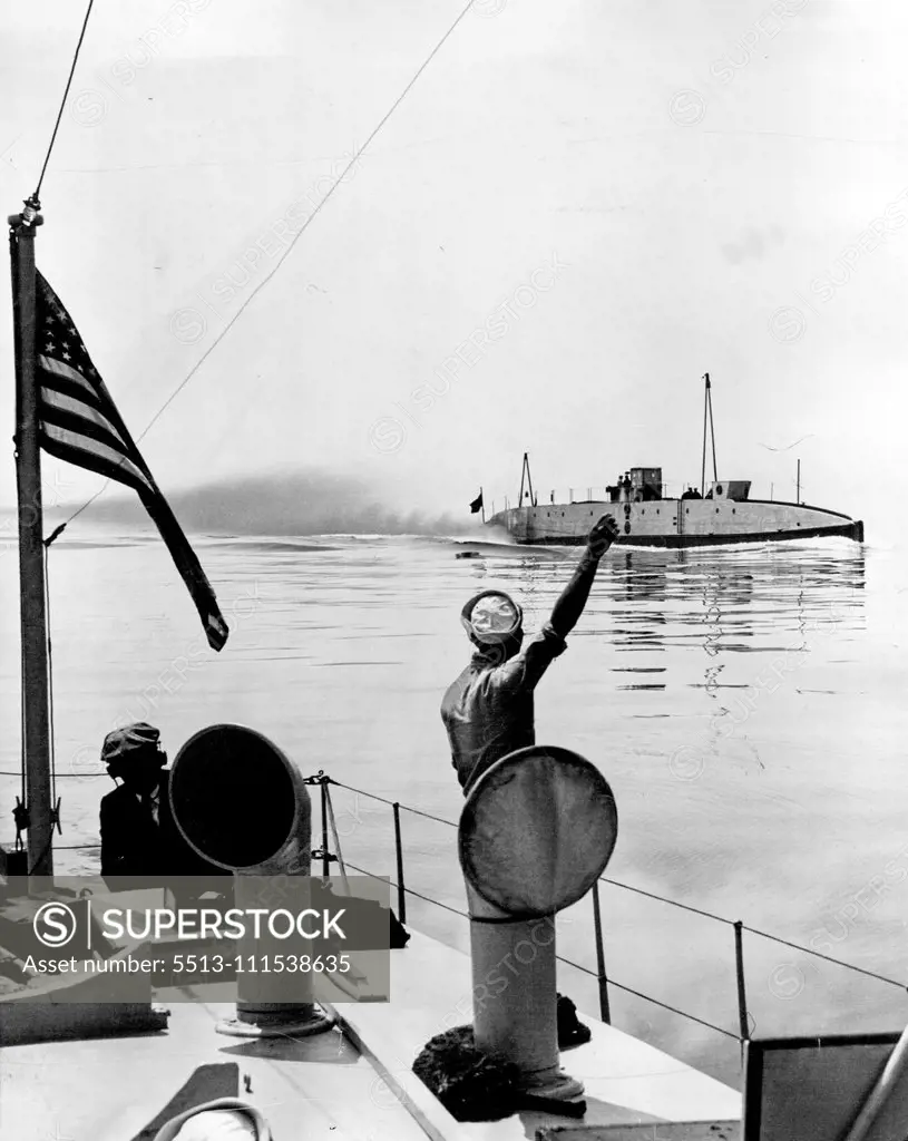 Off for the North Pole: A sailor attached to the U.S.S. Hunt, waving from the deck of that vessel as the submarine "Nautilus" passes cut of the provincetown harbor, bound for Spitzbergen, the "hopping off" point for her trip to the North Pole. After last minute standardization tests here, the nautilus left late last night June 4th on her epochal journey. The nautilus, under Sir Hubert Wilkins, noted explorer, will be convoyed as far as the grand banks by the coast guard cutter Pontchartrain. Jun