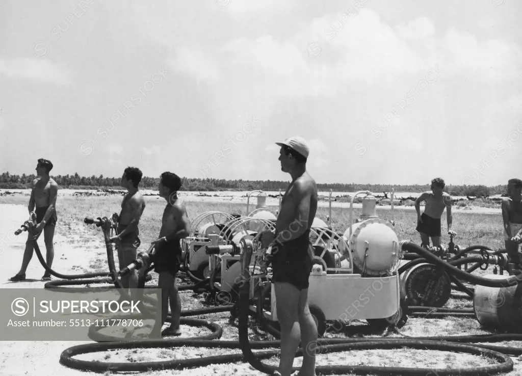 An Australian refuelling party at the edge of the airstrip on Cocos Island, waiting for a plane to land. October 12, 1953. (Photo by Qantas Photograph).