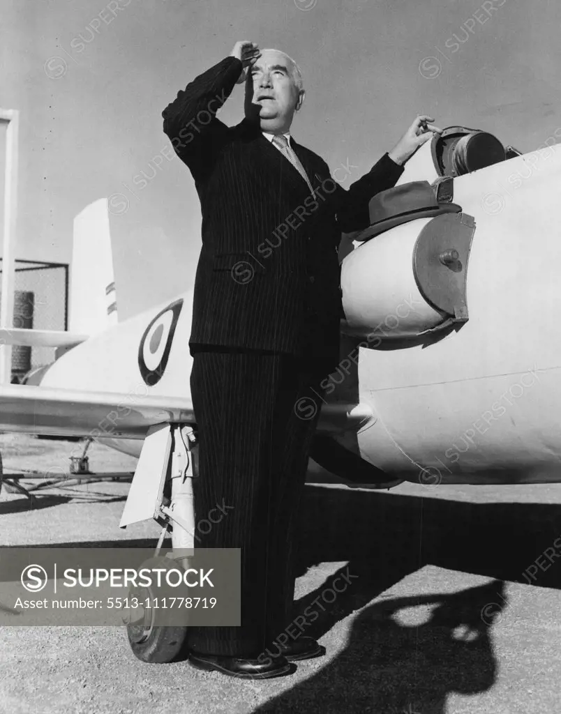 The Prime Minister (Mr. Menzies) leans against a Jindivik and watches a RAAF Metero jet fighter, which controlled the Jindivik by radio in a flight test. May 01, 1953.