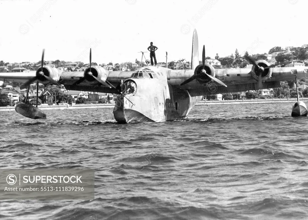 Sunderland Flying Boat moving slowly up to a mooring buoy at Rose Bay delete air standards each ***** of man standing. March 28, 1944.