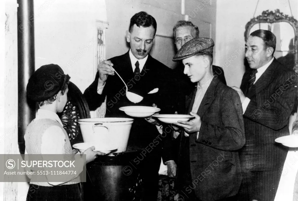 Flight Of Jewish Children Into Holland - refugees From Germany -- Centre, Herr Boddons Hosang, Burgomaster of Naarden, helping in giving food to the Jewish children. Since the Barbaric Drive against the Jews in Germany, Jewish children have been crossing the Dutch Frontier from the neighborhood of Frankfurt in Germany. Twenty-three arrived on the night of November 15 and went to Naarden, near Amsterdam Holland, where the Dutch authorities are looking after them, other Batches of children are ex