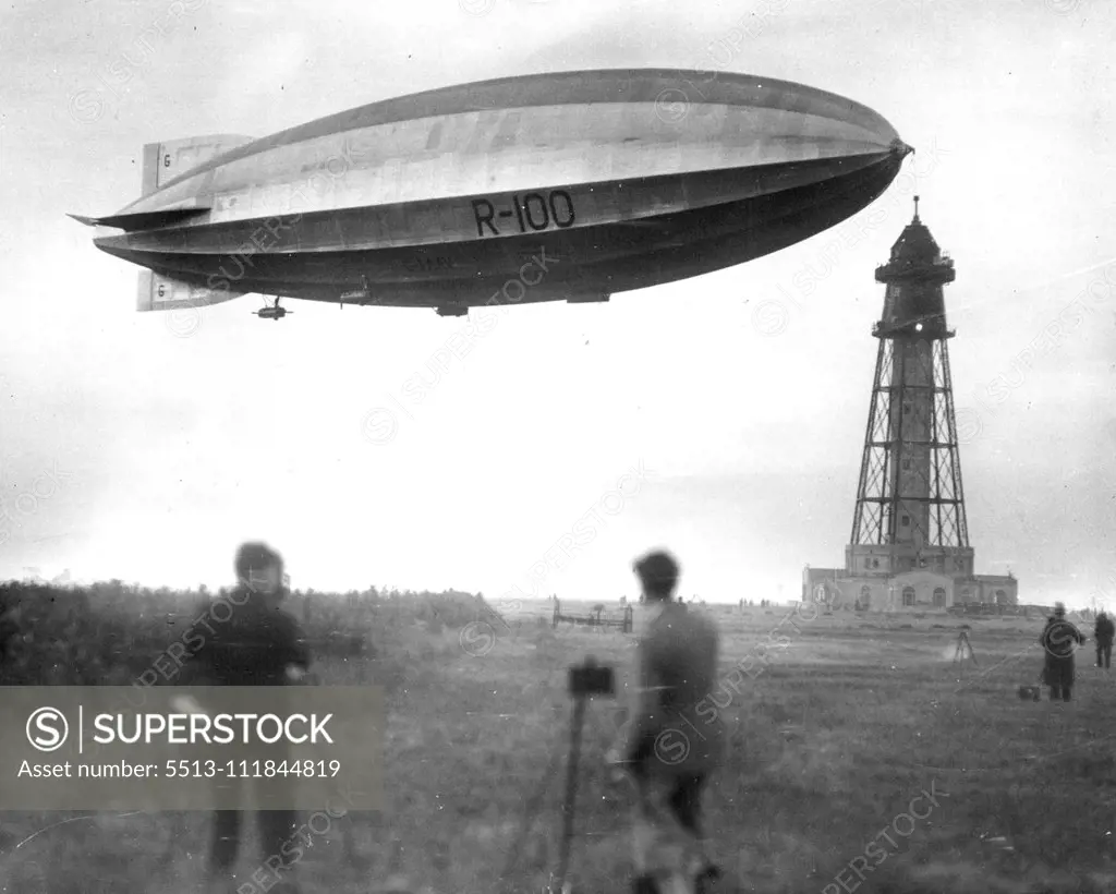 A Giant Visitor -- From Out Of The Clouds: Greeted by the wild cheers of enthusiastic spectators and the whir of airplane propellers, the stately R-100, Newest dirigible king of the Atlantic, Gracefully points its nose toward the new $1,000,000 Mooring-Mast especially constructed in her new world. This view, taken from the ground, shows the giant visitor just before actual contact with the mast had been established by means of the land and aerial cables which had been hocked together. January 8,