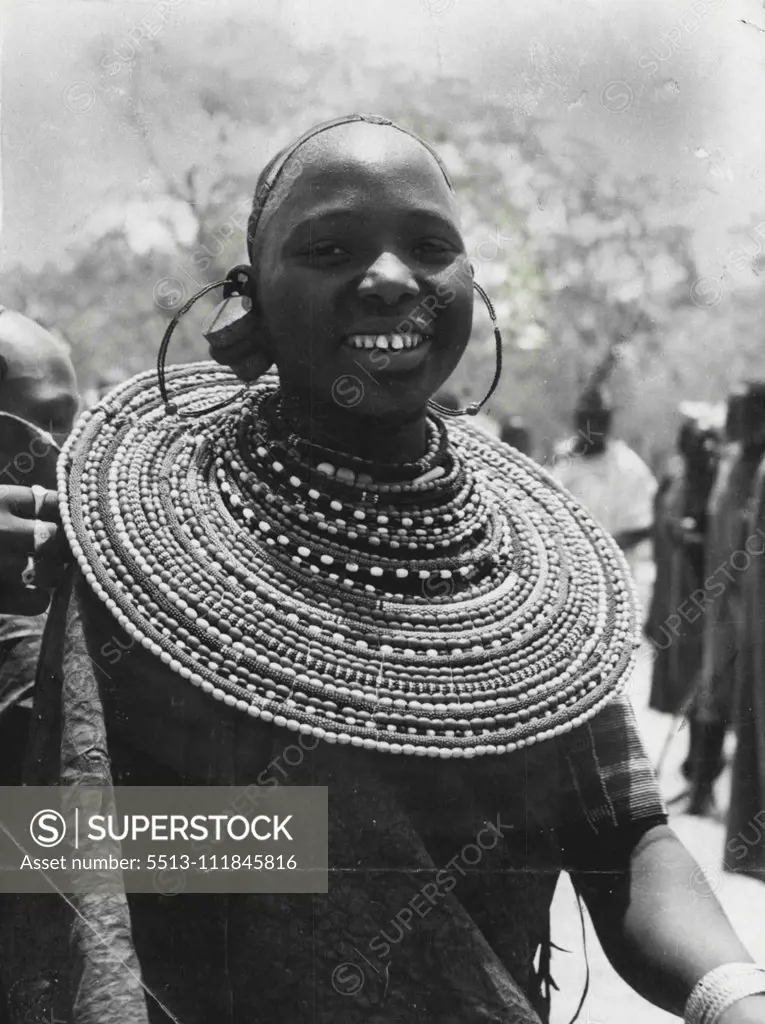 Beauty's Place In The Sun -- The enormous beaded collar dwarfs even the outsize earrings of this smiling Warush beauty, one of the dancers who performed ancient African tribal dances at the agricultural show held at Arusha in the Northern Province of Tanganyika. January 15, 1953. (Photo by Reuterphoto).;Beauty's Place In The Sun -- The enormous beaded collar dwarfs even the outsize earrings of this smiling Warush beauty, one of the dancers who performed ancient African tribal dances at the agric